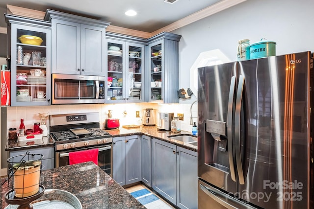 kitchen featuring dark stone countertops, gray cabinetry, tasteful backsplash, and stainless steel appliances