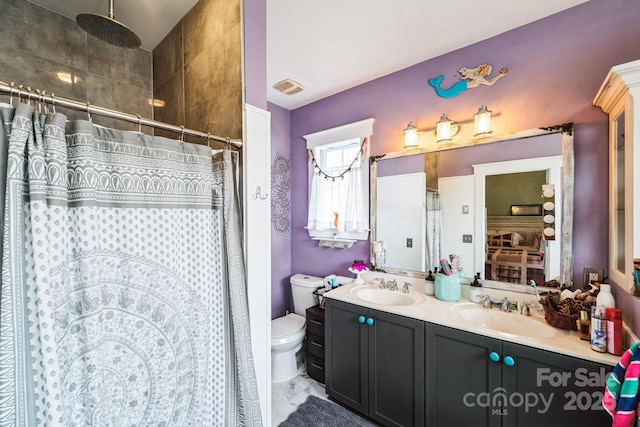 bathroom featuring a sink, toilet, a shower with shower curtain, and double vanity