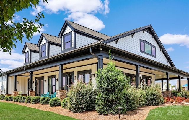 view of home's exterior with covered porch and a shingled roof