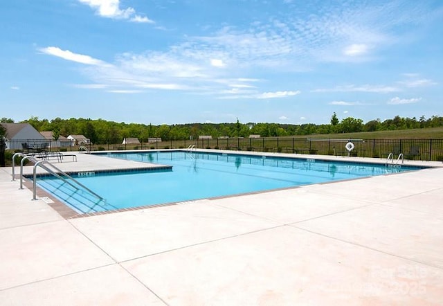 community pool featuring a patio area and fence