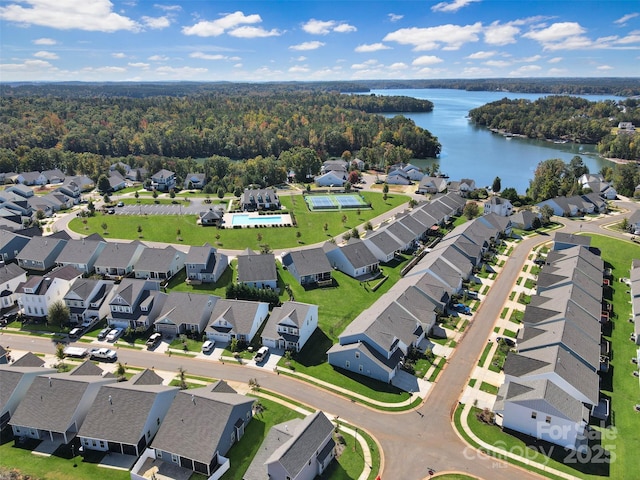 bird's eye view featuring a wooded view, a water view, and a residential view