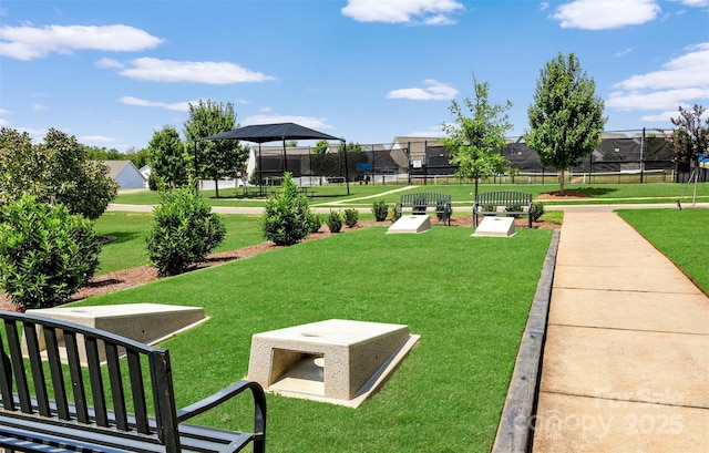 view of community featuring a lawn and fence