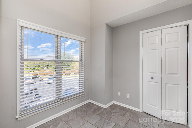 unfurnished bedroom with a closet and baseboards