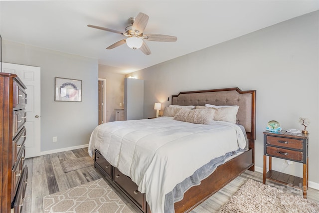 bedroom with light wood-type flooring, baseboards, and a ceiling fan