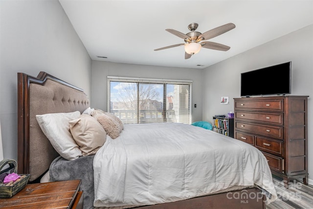 bedroom with visible vents, light wood finished floors, and ceiling fan