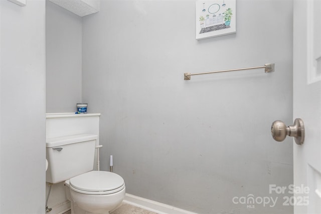 bathroom with baseboards and toilet