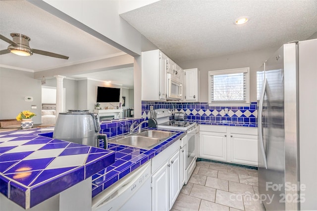 kitchen featuring backsplash, white appliances, white cabinetry, and tile counters