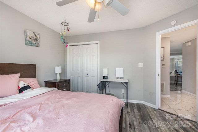 bedroom featuring a closet, visible vents, baseboards, and wood finished floors