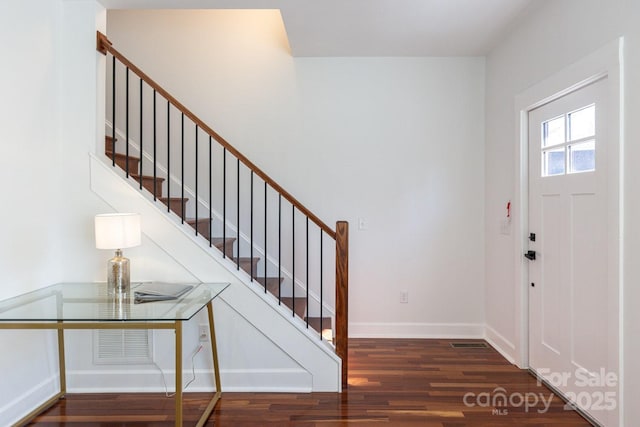 foyer entrance featuring stairway, baseboards, visible vents, and wood finished floors