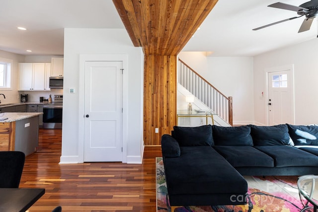 living room featuring baseboards, stairs, recessed lighting, dark wood-style floors, and a ceiling fan