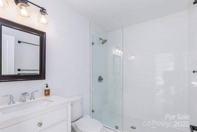 full bath with toilet, vanity, and a tile shower