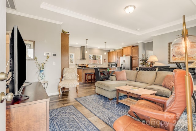 living area featuring visible vents, wood finished floors, recessed lighting, crown molding, and baseboards