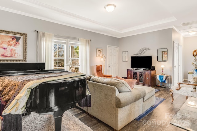 living room with visible vents, wood finished floors, and crown molding