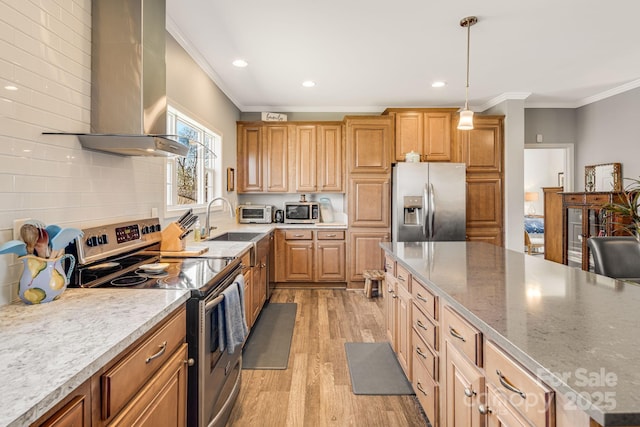 kitchen with a sink, appliances with stainless steel finishes, wall chimney exhaust hood, and ornamental molding