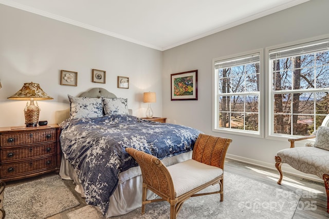 bedroom with wood finished floors, baseboards, and ornamental molding