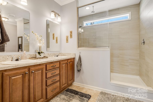 bathroom featuring a sink, crown molding, double vanity, and a tile shower