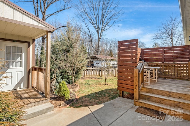 view of yard featuring a patio, a deck, and fence