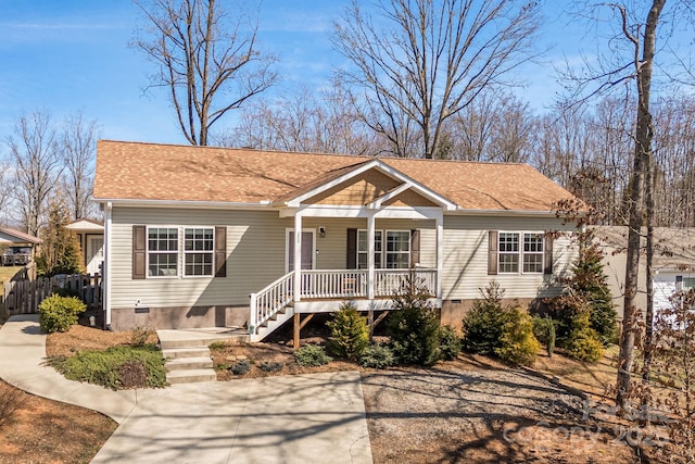 view of front of house featuring a shingled roof, a porch, fence, and crawl space