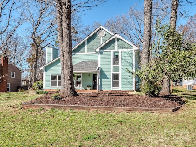 view of front of property featuring a chimney, covered porch, a front yard, and a shingled roof