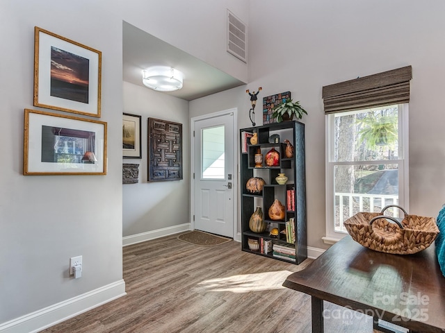 entrance foyer featuring wood finished floors, visible vents, and baseboards