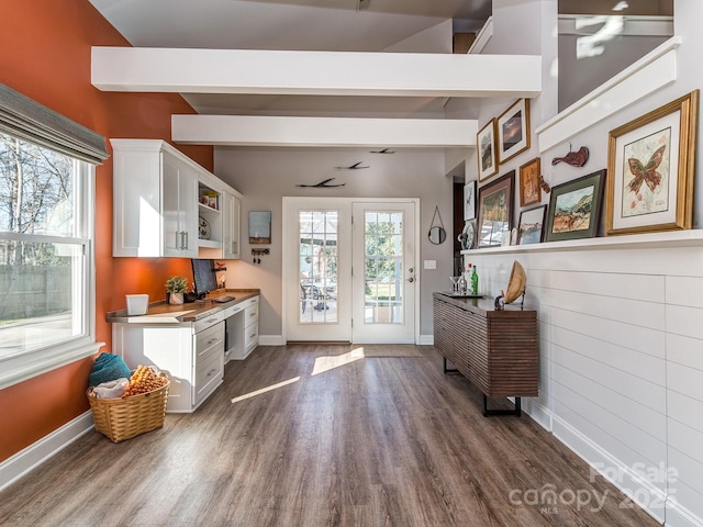 kitchen featuring a wealth of natural light, beamed ceiling, white cabinetry, and dark wood-style floors