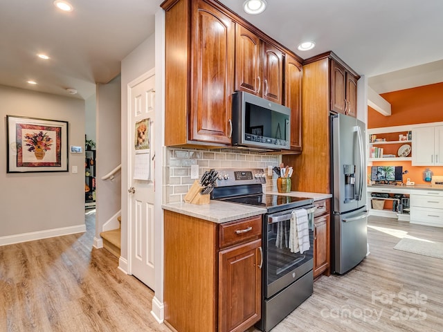 kitchen with light wood-style flooring, recessed lighting, decorative backsplash, light countertops, and appliances with stainless steel finishes