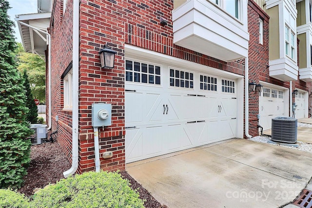 garage with central air condition unit and driveway