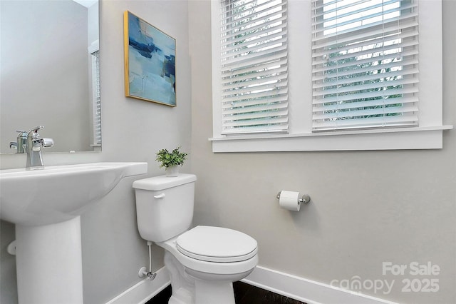 bathroom featuring toilet and baseboards