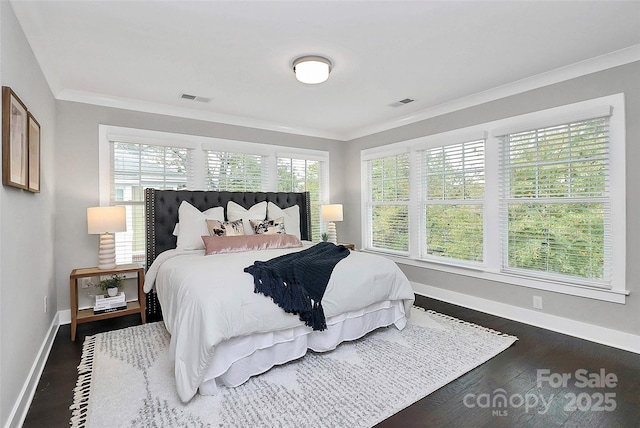 bedroom featuring dark wood-style floors, visible vents, crown molding, and baseboards