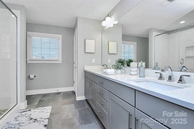 bathroom featuring baseboards, visible vents, double vanity, a sink, and a shower stall