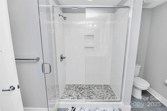 bathroom featuring tile patterned floors, baseboards, toilet, and a stall shower