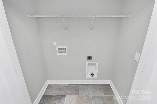 clothes washing area with stone tile flooring, baseboards, hookup for an electric dryer, hookup for a washing machine, and laundry area