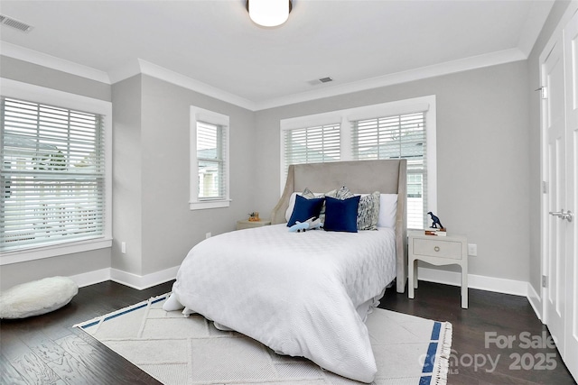 bedroom featuring visible vents, ornamental molding, baseboards, and dark wood-style flooring