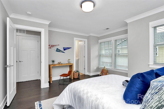 bedroom with visible vents, wood finished floors, baseboards, and ornamental molding