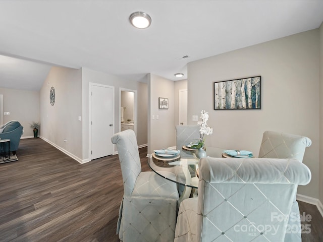 dining space featuring dark wood finished floors and baseboards