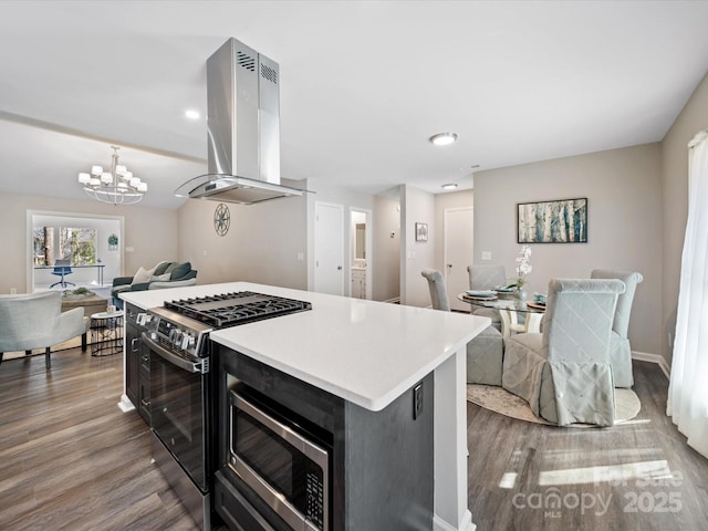 kitchen featuring open floor plan, wood finished floors, stainless steel appliances, and island range hood