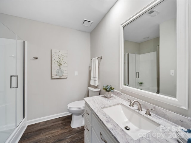 bathroom with a shower stall, toilet, wood finished floors, and visible vents