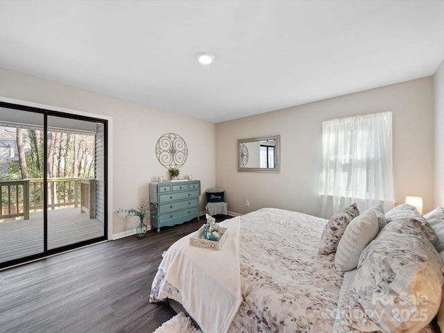 bedroom featuring dark wood-style flooring, multiple windows, baseboards, and access to outside