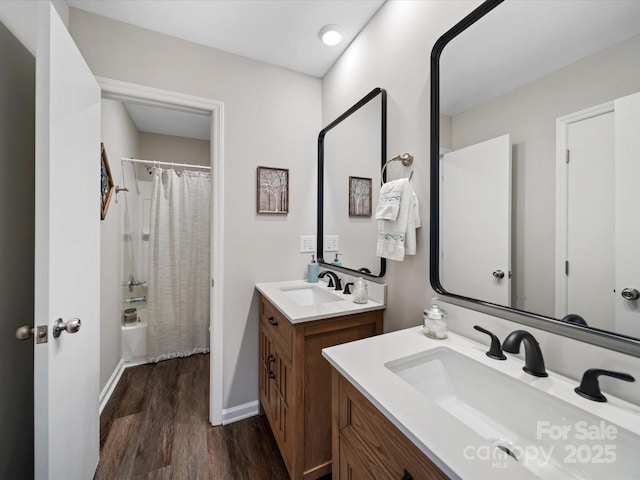 full bathroom featuring shower / tub combo, two vanities, wood finished floors, and a sink