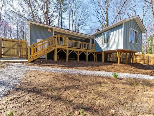 back of house featuring stairway, fence, a wooden deck, and a gate