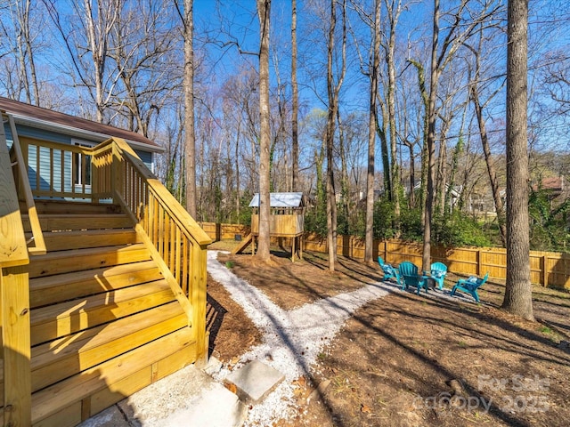 view of yard with stairway, fence, and a playground