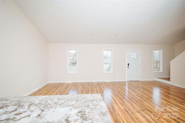 interior space with baseboards and light wood finished floors