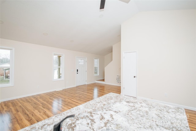 bedroom featuring multiple windows, light wood-style flooring, baseboards, and ceiling fan