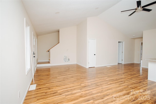 unfurnished living room with baseboards, high vaulted ceiling, a ceiling fan, and light wood finished floors