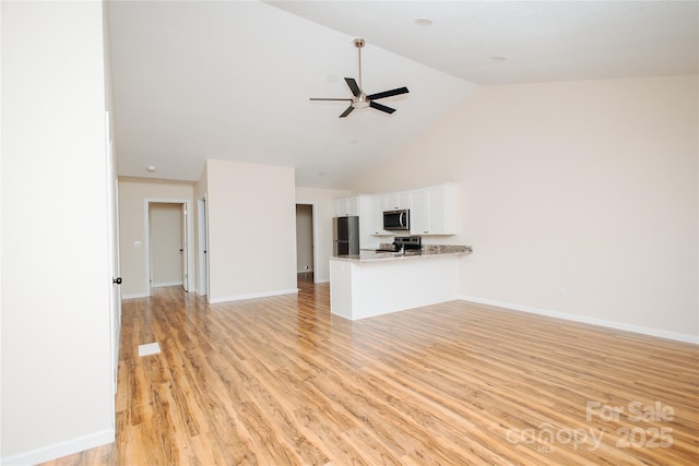 unfurnished living room featuring a ceiling fan, light wood-style floors, baseboards, and high vaulted ceiling