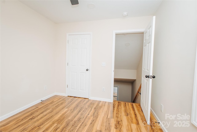 unfurnished bedroom featuring a ceiling fan, baseboards, and wood finished floors