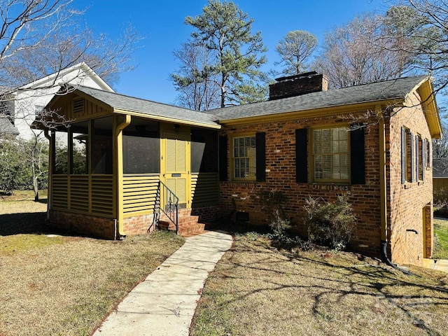 bungalow featuring a sunroom, a chimney, entry steps, crawl space, and brick siding