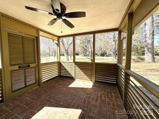 unfurnished sunroom featuring a ceiling fan