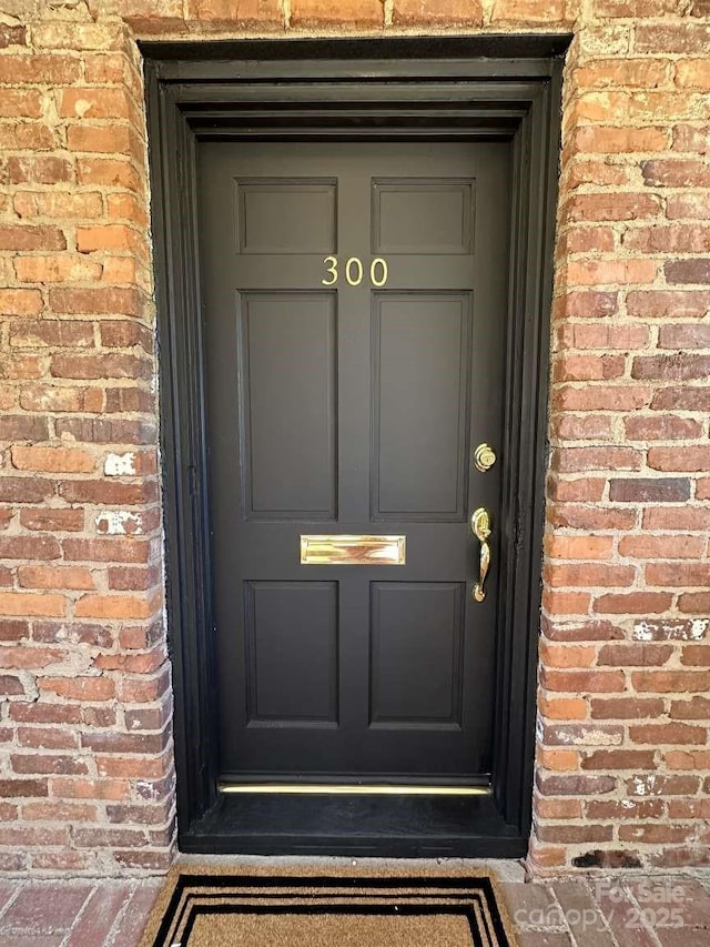 doorway to property with brick siding