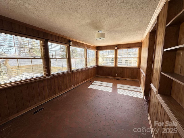 unfurnished sunroom featuring visible vents